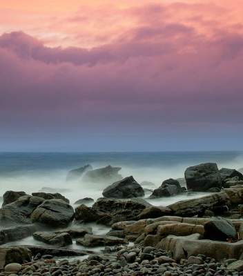 chronic illness page - pink and purple clouds over seascape with rocky shore